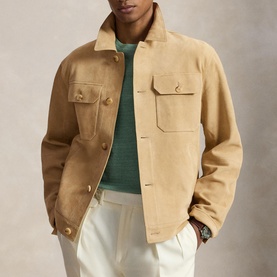 Model wearing Ralph Lauren Cafe Tan casual jacket with gold buttons and chest pockets, styled with green knit and white trousers
