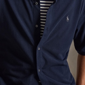 Model wearing navy Polo Ralph Lauren short-sleeve button-down shirt, styled over a navy striped top