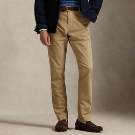 Model wearing Ralph Lauren khaki chino trousers with a navy blazer, brown leather belt and suede loafers.