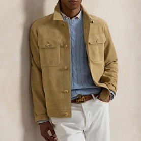 Model wearing tan suede-effect shirt jacket with chest pockets, styled with blue knit, white trousers and leopard-print belt