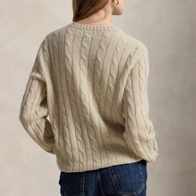 Model wearing cream cable-knit jumper, back view, styled with blue jeans