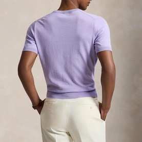 Model wearing Ralph Lauren powder purple short-sleeve crew neck knit, styled with cream tailored trousers, back view.
