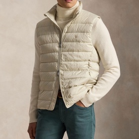 Model wearing Ralph Lauren basic sand quilted gilet over cream roll-neck knit, styled with teal trousers
