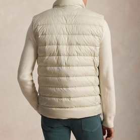 Model wearing Ralph Lauren Basic Sand quilted gilet, back view, styled with cream knit and teal trousers