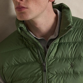 Model wearing Ralph Lauren green quilted gilet with zip fastening and embroidered logo, styled over a grey top
