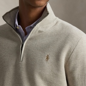 Model wearing Ralph Lauren Half Zip in light walnut brown heather, styled with a blue striped shirt, gold polo pony embroidery at chest.