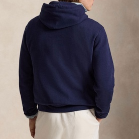 Model wearing Ralph Lauren navy hoodie, back view, styled with white trousers
