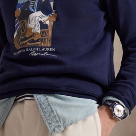 Model wearing Ralph Lauren navy Polo Bear hoodie, styled with light beige chinos and a chronograph watch.
