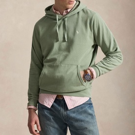 Model wearing Ralph Lauren light green hoodie with kangaroo pocket, styled with pink shirt and blue jeans