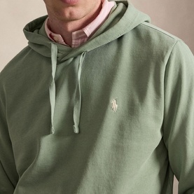 Model wearing Ralph Lauren light green hoodie with drawstring hood and embroidered polo pony logo, styled over pink check shirt.