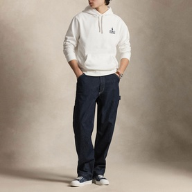 Model wearing Ralph Lauren white hoodie with small chest logo, styled with dark indigo carpenter jeans and navy canvas trainers.