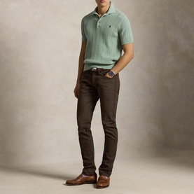 Model wearing Ralph Lauren Circuit Brown jeans, styled with a mint green knit polo shirt and brown leather shoes.