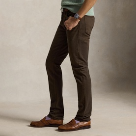 Model wearing Ralph Lauren circuit brown slim-fit jeans, styled with tan leather loafers and lilac socks