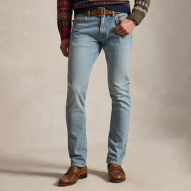 Model wearing Ralph Lauren blue slim-fit jeans with brown leather belt and tan loafers, styled with a patterned knitwear top