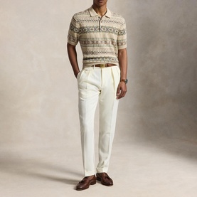 Model wearing a beige Fair Isle knit polo shirt with cream trousers and brown leather loafers