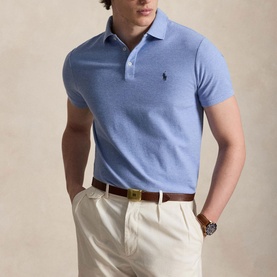 Model wearing light blue Polo Ralph Lauren polo shirt with logo embroidery, styled with cream trousers and brown leather belt