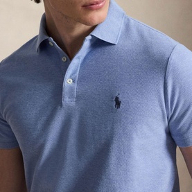 Model wearing blue textured polo shirt with navy embroidered Polo Ralph Lauren pony logo and two-button placket