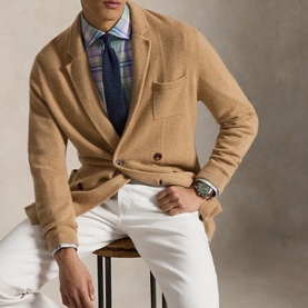 Model wearing Ralph Lauren Reg Shirt in Faded Mint Lavender Multi plaid, styled with a camel blazer, white trousers and a watch.