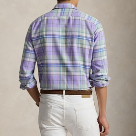 Model wearing Ralph Lauren Reg Shirt in lavender and green multi plaid, back view, styled with white trousers and tan belt.