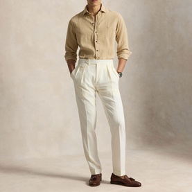 Model wearing Ralph Lauren Coastal Beige linen regular shirt, styled with white pleated trousers and brown tassel loafers.