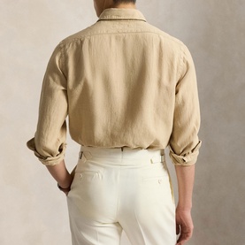 Model wearing Ralph Lauren Coastal Beige linen reg shirt, back view, rolled sleeves, styled with white trousers