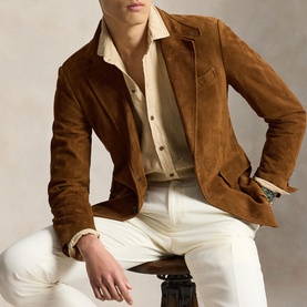 Model wearing Ralph Lauren Reg Shirt in Coastal Beige, styled with a tan suede jacket and white trousers.