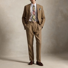 Model wearing Ralph Lauren Reg Shirt in powder purple white, styled with tan suit, plaid tie, and brown loafers