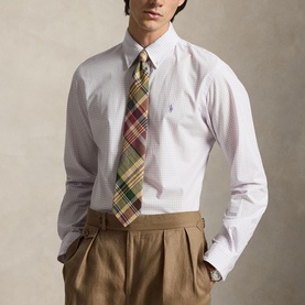 Model wearing Ralph Lauren Reg Shirt in powder purple and white check, styled with a multicoloured madras tie and khaki trousers.
