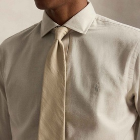 Model wearing Ralph Lauren Performance Twill Logo Shirt in Expedition Dune Heather, styled with a coordinating cream tie.