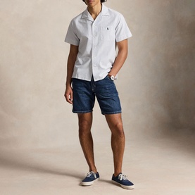 Model wearing Ralph Lauren Reg Shirt in white, styled with navy denim shorts and canvas trainers. Embroidered polo pony logo at chest.