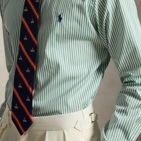 Model wearing Ralph Lauren Reg Shirt in faded mint and white stripe, styled with a navy regimental stripe tie and cream trousers.
