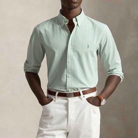 Model wearing Ralph Lauren Pony Logo Striped Poplin Shirt in faded mint and white, styled with white trousers and brown belt.