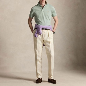 Model wearing Ralph Lauren Light Green Regular Polo with cream pleated trousers, lavender jumper tied at waist, and dark brown loafers.
