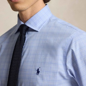 Model wearing Ralph Lauren Glen Plaid Poplin Shirt in Harbour Island Blue with navy knit tie. Embroidered pony logo at chest.