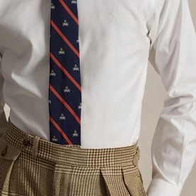 Model wearing Ralph Lauren white single cuff regular shirt, styled with navy striped tie and tan houndstooth trousers.