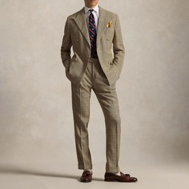 Model wearing Ralph Lauren white single cuff regular shirt styled with tan houndstooth suit, striped tie, pocket square, and brown tassel loafers.