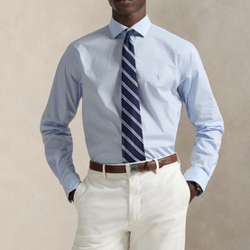 Model wearing Ralph Lauren Light Blue Single Cuff Regular shirt with navy striped tie and cream chinos