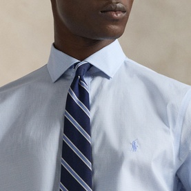Model wearing Ralph Lauren Light Blue Single Cuff Regular shirt with navy striped tie, embroidered logo at chest