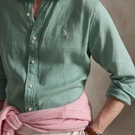 Model wearing Ralph Lauren Slim Shirt in faded mint linen, button-down collar, styled with pink trousers tied at waist.