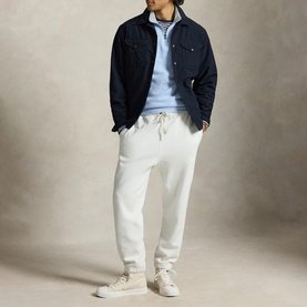 Model wearing Ralph Lauren Office Blue sweatshirt with navy overshirt, white joggers and cream trainers.