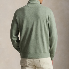 Model wearing Ralph Lauren green quarter-zip sweatshirt, back view, styled with light beige trousers