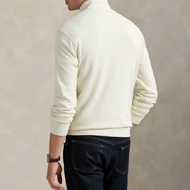Model wearing Ralph Lauren cream turtleneck sweatshirt, back view, styled with dark navy jeans