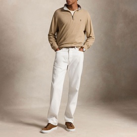 Model wearing Ralph Lauren Polo Player Half-Zip Pullover in Warm Brown Heather with white trousers and tan suede trainers.