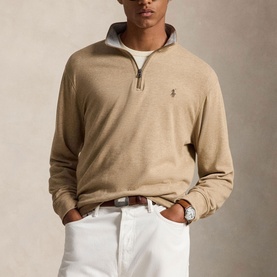 Model wearing Ralph Lauren Polo Player Half-Zip Pullover in Warm Brown Heather, styled with white trousers and a watch.