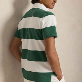 Model wearing Ralph Lauren striped polo shirt in Antique Green and Oxford White, short sleeves, rear view, styled with white trousers