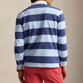 Model wearing Ralph Lauren light navy and elite blue stripe long-sleeve rugby sweatshirt, back view, styled with red chinos.