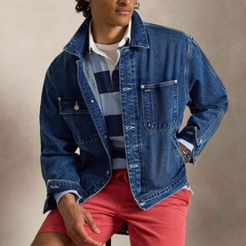 Model wearing Ralph Lauren light navy and elite blue striped sweatshirt, styled with a mid-blue denim jacket and red shorts.