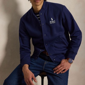 Model wearing Ralph Lauren Newport Navy bomber-style sweatshirt with logo embroidery, styled with blue jeans and a striped top.
