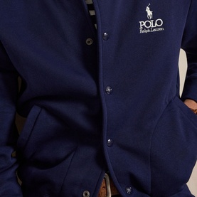 Model wearing Ralph Lauren Polo Newport Navy snap-button sweatshirt with embroidered logo, styled with a brown leather belt.