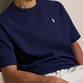 Model wearing Ralph Lauren T-Shirt in Newport Navy, with embroidered polo pony logo at chest, paired with white trousers.